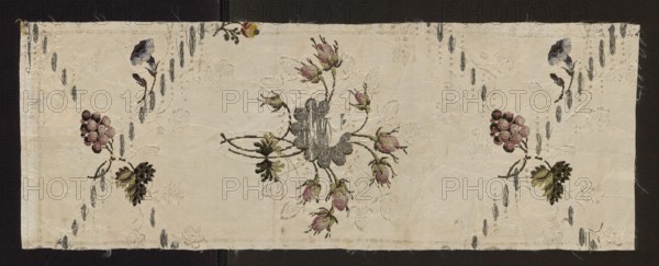Fragment of silk fabric, mid-18th century, England possibly. Patterned Gros de Tours, broché silk with rep-weave background and broaching threads persienne. Design of twigs and bouquets in a rhomboidal network of small silver motifs; branches bear grape clusters, rose buds and single flowers. Colors: white background with padding threads in light and dark pink, light and dark green, light and dark blue; delicate floral and fanciful motifs. Dimensions: length 38 x ? cm; height 21 cm; width 57 cm., A rectangular piece of light beige fabric with a central embroidered floral cluster and smaller matching floral clusters toward the sides, showing a few rosebud shapes in muted pinks and greens, a few dark gray and black leaf-like motifs, and a few small grape-like round shapes in dusky pink and maroon; the background fabric has a subtle woven leaf pattern in a slightly lighter tone, and there are scattered short vertical dash-like stitches in gray; the edges of the fabric show a sewn hem and ...