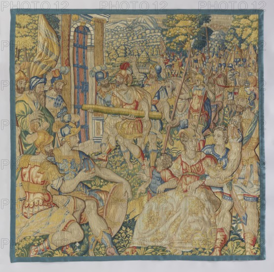 Figural tapestry by Franz Geubels 1535–1590, 16th century Flanders Brussels. Tapestry depicting a battle scene and interior furnishings: in the foreground, two groups — on the right a woman with children seated and a standing soldier, on the left two seated soldiers with bearded men standing behind them. In the background, a city gate being forced open by soldiers with a pole, an army with banners beyond, and a mountain landscape. No border. Colors: green, red, sapphire blue, sand, and yellow. Woven fabric, height 215 cm, width 217 cm. Date text also notes 2nd half of the 19th century in provenance., A richly colored woven textile scene shows a group of elaborately dressed figures in an outdoor setting, with a mix of armor, flowing robes, plumed helmets, and patterned fabrics. The dominant colors include gold, blue, red, green, and beige, with accents of darker blue and pale yellow. Several seated and standing figures occupy the foreground, some holding staffs or banners and others wit...