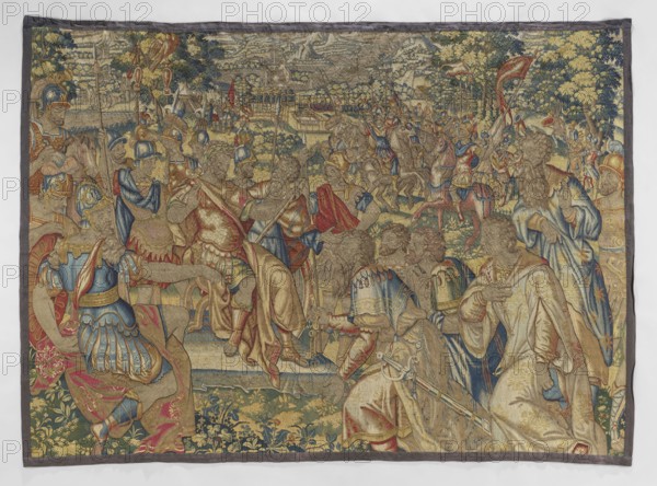 Figural tapestry by Franz Geubels 1535–1590, 2nd half of the 16th century, Flanders Brussels. Wool and silk tapestry, height 218 cm, width 295 cm. Depicts a horizontal battle/conquest scene: in the foreground at right a kneeling group of delegates from a defeated city; on the left a kneeling soldier points to keys held by the first delegate. On a slightly raised dais at center, surrounded by soldiers, sits the victorious commander wearing a laurel crown. In the middle foreground men on wheels hand him keys; soldiers kneel to the left. In the background an approaching army on horseback, with city walls, gardens, trees and a mountain landscape; high horizon partly obscured by trees and mountains. No border border clipped in another version. Limited, saturated palette; predominant colors green, red, sapphire, with sand and yellow. Subjects: battle scenes, figures in military costume, soldiers; function: interior decoration/ornamental fabric., The image shows an ornate woven tapestry depic...