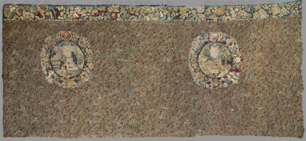 Tapestry, 16th century late 16th century, Flanders. Preserved fragment of fabric, height 164 cm, width 365 cm. Millefleurs tapestry: entire surface densely strewn with motifs of small flowering plants on a black background; ornament colors red, green, dark navy blue, and sand. Slightly above the horizontal axis are two medallions, each framed by a thick wreath of fruit, flowers, scrollwork motifs, and a mascaron. One medallion depicts a rural landscape with architecture and an emblem with a jug at the top; the other shows a forest landscape with a moose and a doe in the foreground and a suspended emblem at the top. The upper border preserved only in the upper part consists of a thick twig of flowers and fruit., A large rectangular woven textile with a dense all-over floral field in shades of green, brown, red, blue, and cream, featuring two round medallions set into the floral background; each medallion is bordered by a band of stylized flowers and foliage in colors including cream, bl...