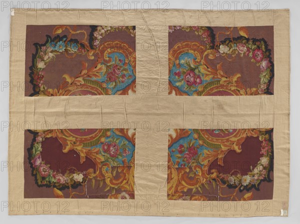 Ornamental tapestry, Cut from a larger piece; in the center, a bouquet of flowers in a medallion made of acanthus leaves. Around it are similar medallions and cartouches with flowers or flower clusters in the center. No border. Colors: plum background, ornament in pink, lilac, blue, green, cream, yellow, and black. 18th/19th century, France. Fabrics; height 320 cm, width 234 cm., A large rectangular textile mounted on a beige fabric background with visible creases shows a patterned interior divided into a grid of four panels; each panel contains ornate decorative motifs in a palette of rich colors including deep maroon, bright blue, golden yellow, orange, pink, green, black, and cream. The patterned areas feature swirling acanthus-like scrolls, floral clusters, and curved shapes with layered colors and textured embroidery or pile; several flowers in shades of pink and cream sit against blue fields framed by golden-orange scrollwork, while black and dark maroon areas provide contrast. T...