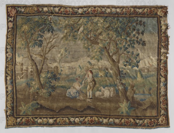 Figural tapestry, flowers, floral ornaments, fruit, trees, pastoral depictions, interior furnishings, tapestries, decorative fabrics, borders, tapestries, weaving. In the center, under the trees, a shepherd with a girl and sheep. In the background, on the left, rural buildings, and on the right, a castle. Border with floral motifs. Colors: green, brown, ochre, and beige. 18th century, France. Fabrics. Height 259 cm, width 340 cm., A worn woven scene framed by a decorative floral border in shades of brown, gold, red, blue, green, and cream shows a pastoral landscape with large leafy trees in green and blue tones, grassy ground in brown and green, and a small body of water with blue highlights. In the foreground a seated figure in muted blue and cream clothing and a standing figure in brown and cream with a red head covering are near a group of white or cream sheep. Background elements include faint structures and fences in muted beige and brown, distant hills in gray and taupe, and scat...
