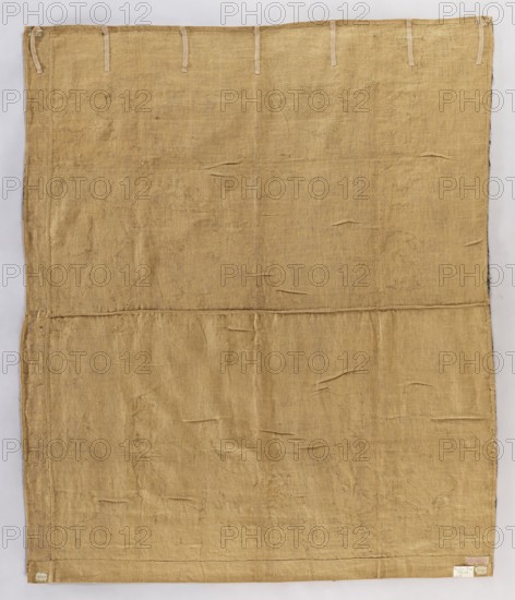 Fragment of a figural tapestry. Flowers, leaves, floral ornaments, warriors in armor, and fabrics depicted; they walk from left to right. On the left, a column entwined with flowers and fruit. No border. Colors: green, sandy green, blue, and red. 16th century, Flanders. Materials: woven fabric. Height 213 cm, width 182 cm., A large rectangular piece of coarse woven fabric fills the image, showing a worn, uneven surface with visible weave texture, creases, and small areas of fraying; the fabric is a tan to beige color with slightly darker and lighter irregular patches, and along the top edge there are a few narrow fabric loops in a pale beige shade; a narrow border runs along the left and bottom edges, and a small pale patch is visible near the lower right corner.