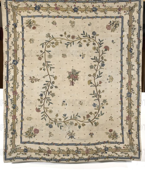 Kilim, Court kilim, decorative fabric kilim with plant and floral patterns. In the center, a small rose bouquet surrounded by a medallion formed by a winding branch with small, various flowers and leaves. The background is decorated with projections of bouquets, flower sprigs, and small geometric ornaments. Large flower bouquets are depicted in the corners. Bordered with three simple frames, each bordered by a winding branch. Colors: white, blue, green, and red. 2nd half of the 18th century. Poland. Height 226 cm; width 192 cm., A large rectangular textile with an off-white background features a decorative border and central floral garland; the border has several layered bands in beige and blue with embroidered vines and a few flowers in blue, pink, yellow, and green, and the interior shows a loose oval of intertwined stems and leaves in green and beige bearing small flowers in blue, pink, yellow, and muted red, with scattered small floral motifs in similar colors across the field and ...
