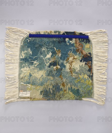 Tapestry chair cover, repossession provenance; motifs: leaves, trees, landscapes, castle buildings on the right, tall trees on the left; interior decorations and furnishings; decorative fabrics. Colors: green, blue, and white. Date: 1st half of the 20th century. Place of origin: Vienna. Material: fabrics. Dimensions: height 53 cm, width 62 cm., A rectangular woven textile with long cream-colored fringe on two opposite edges lies flat against a light gray background, the central woven area showing a textured, loose pile with varied yarns and a mottled pattern in teal, blue, cream, green, yellow, brown, and hints of rust, with a narrow deep blue strip along the top edge; the fringe is cream and the woven field displays tangled loops and tufts creating an abstract, painterly appearance.