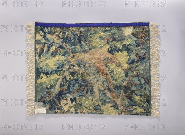 Tapestry chair cover, Repossession provenance. Depicts leaves, floral ornaments, trees, birds among thick foliage. Fabrics, upholstery for furniture; decorative interior textile. Colors: yellow, green, blue, and pink. 1st half of the 20th century, Vienna. Height 65 cm, width 82 cm., A rectangular woven textile with fringed edges laid flat against a pale background, showing a dense, textured surface of tangled yarns and threads. The textile displays a mix of colors including various shades of blue, green, yellow, cream, beige, brown, and a touch of rust, with a darker blue or purple strip along one short edge. The edges have cream-colored fringe on the two long sides, and the woven area contains a layered, organic pattern of looping and loose threads creating a sculptural, fibrous appearance.