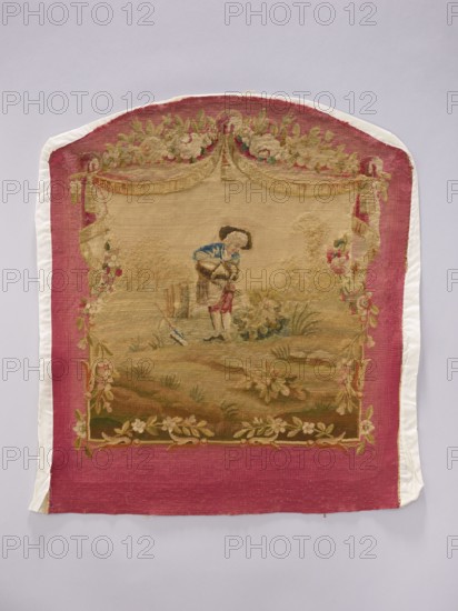 Tapestry covering, creator unknown, provenance, floral ornaments, boys, pastoral scenes; fabrics, interior decorations, interior furnishings, decorative fabrics, flowers, tapestries, gobelins, furniture upholstery, draperies suspended at the top, and flowers around. Colors: beige, cream, pink, blue, and red. After the mid-18th century. Possibly Beauvais or Aubusson. Height 69 cm, width 59 cm., A rectangular textile with a rounded top, bordered by a wide band of deep pink and edged with a narrow white trim, featuring a central woven scene in muted beige and brown tones; the scene shows a person wearing a blue upper garment and darker headwear standing on grassy earth tones with green and brown plants and floral motifs, framed by decorative garlands and swags in shades of green, pink, cream, and gold, with additional floral embellishments along the bottom in pale pink and green.