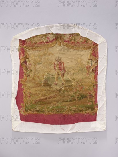 Tapestry covering, creator unknown, provenance, floral ornaments with flowers and leaves, boys, pastoral scenes; fabric tapestry used for interior furnishings and furniture upholstery, with hanging draperies at the top and flowers around. Colors: beige, cream, ochre, green, blue, pink, and red. Post–mid-18th century. Possibly Aubusson or Beauvais origin. Materials: fabrics. Height 70 cm, width 58 cm., An aged textile panel with frayed edges framed by a white cloth border, showing a worn central scene in muted beige, tan, and gold tones with touches of red, green, and pink; the panel has areas of loose threads and textured stitching, a red fabric band along the outer edge of the scene, and a small metal ring at the top, all set against a pale gray background.