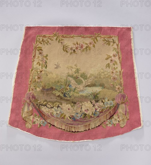 Tapestry covering, creator unknown, provenance, depicts flowers, leaves, floral ornaments, swans, boys, a swallow at the top, draperies below and flowers around; used for interior decorations, fabrics, furniture upholstery; style: gobelins/decorative fabric; colors: beige, green, blue, cream, pink; after the mid-18th century; possibly Aubusson or Beauvais origin; height 58 cm, width 67 cm., A decorative woven textile with a wide pink border surrounding a central beige field that contains a scenic woven image; the central scene shows a pale-colored swan on a pond amid green foliage and grasses with a small bird flying above, and the area is framed by garlands of leaves and flowers in shades of green, pink, and cream; the lower part of the design features a floral swag and draped fabric elements in muted pinks, creams, blues, and greens, with tassel-like fringe details and additional small flowers; the overall color palette includes pink, beige, cream, green, blue, and hints of brown.