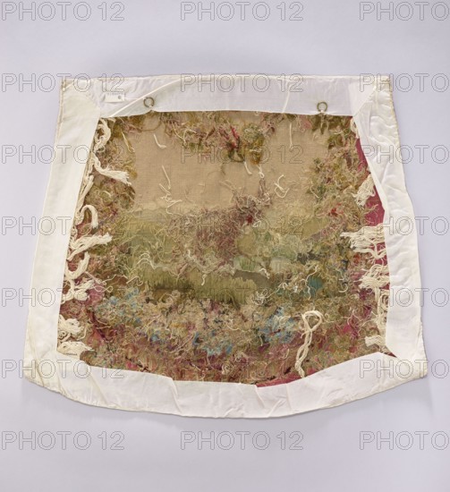 Tapestry covering, provenance, flowers, leaves, floral ornaments, oxen, boys; interior decorations, fabrics, interior furnishings, tapestries, decorative fabrics, gobelins, furniture upholstery, draperies at the bottom with flowers around. Colors: beige, pink, sky blue, ochre, and olive. Post–mid-18th century. Possibly Beauvais or Aubusson. Fabric. Height 57 cm, width 68 cm., A rectangular textile piece with a white fabric border lies flat against a pale background; the central area shows a worn, loosely woven surface with a tangled mass of threads and yarns creating a shaggy, textured appearance. The visible colors include beige and tan in the base fabric, with scattered greens, pinks, reds, blues, and off-white threads throughout the tangled areas. The white border has folds and stitched corners, and there are a few metal rings attached near the top edge. Several loose tassel-like off-white threads hang from the sides and bottom, and the overall surface appears frayed and uneven with...