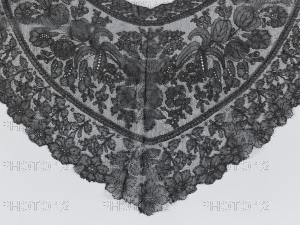 Mantilla, purchase provenance; floral ornaments; Chantilly lace; lace; clothing accessory; women's clothing; fashion; mantilla; triangular with highly raised upper corners; 2nd half of the 19th century; France; height 36 cm, A triangular piece of black lace fabric with an ornate floral embroidery pattern, showing several large stylized flowers, leaves, and clusters of smaller blossoms arranged symmetrically along the central fold; the lace has scalloped edges with dense floral motifs and a fine netted background visible through the embroidery, and the visible colors are shades of black and gray.