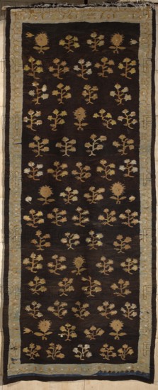 Kilim, kilim, flowers, interior design, Poland culture, decorative fabrics, floral patterns. The main field of the kilim is filled with motifs of stylized flower branches arranged in alternating vertical rows; the branches are four-flowered or single-flowered. Surrounded by a border with a geometrical floral tendril motif. Colors: background of the main field is brown, borders are light blue, ornamentation golden yellow. ca. 1830, Poland, fabrics, height 376 cm, width 148 cm., A long rectangular textile with a dark brown background framed by a pale blue-gray border; the interior is patterned with a repeating arrangement of small stylized floral motifs in shades of tan, beige, light brown, and muted yellow, with a few motifs showing lighter off-white highlights; the border contains a subtle decorative motif in similar pale tones and the outer edge shows narrow bands of darker brown and a thin strip of deep blue; the textile shows frayed edges at one end and slight irregularities in weav...