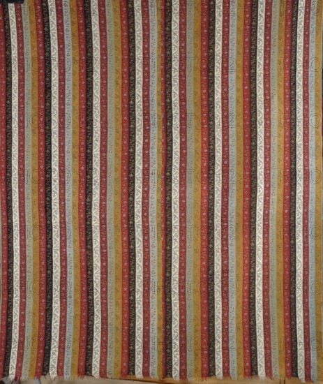 Cashmere shawl, purchased provenance. Fashion; women's clothing and accessory; cashmere shawl with geometric and plant ornaments. Early 19th century, Iran. Shawl with a pattern of colorful stripes with fine ornamentation: repeating color sequence of ochre, sky blue, red, white, black, red, light blue, alternating with parrot green. Sewn from two pieces: one piece has preserved workshop edges 69 cm wide, the other is narrower without a selvedge. Length 256 cm, width 132 cm., The image shows a patterned textile with many vertical striped bands in a repeating arrangement. The stripes include colors such as red, mustard yellow, pale blue, cream, black, and olive green, each containing small decorative motifs and subtle texture variations. The textile edges show a short fringe at the bottom and the overall surface has a woven appearance with slight irregularities in the stripe widths and motifs. The pattern fills the entire frame.