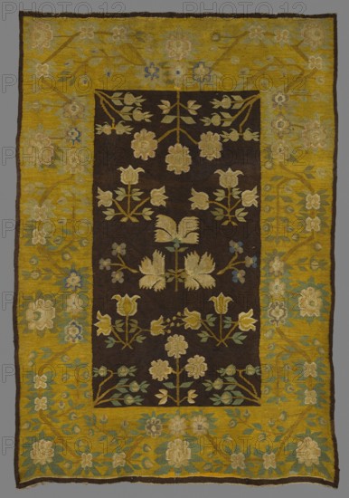 Kilim, kilim, interior design, flowers, decorative fabrics, floral patterns, Poland culture. In the center is a motif of a simple branch with three feathery flowers, surrounded by motifs of bouquets and floral branches filling the entire main field. In the corners are diagonally placed motifs of branches with flower buds, and at the shorter edges are two simple branches with rosette flowers. A wide border with a floral tendril motif surrounds the fabric. Colors: main field background brown, borders yellow; ornament in green, beige, yellow, blue, pink, celadon and light brown. 19th century, Poland; fabrics; height 243 cm, width 168 cm., A rectangular textile with a dark central field and a wide yellow border, featuring a repeating floral pattern; the central area is brown with stylized cream and pale yellow flower motifs and green leaves arranged symmetrically, and the yellow border contains larger floral and leafy designs in cream, pale blue, muted green, and beige, with the outer edge...