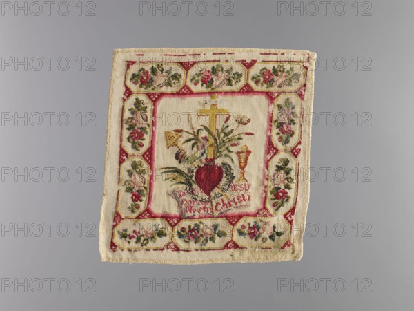 Pall, origin unknown, church parament featuring crosses, chalices, and plant ornaments; sacred art for churches and chapels furnishings; liturgical parament, 1840s; height 17 cm, width 17 cm, A square textile with a central embroidered design surrounded by a decorative border is visible; the fabric is a light beige or cream color with embroidered areas in red, pink, green, yellow, gold, and dark brown. The central panel shows a heart-shaped motif in deep red with surrounding green leaves and stems, a gold-colored cross above it, and a chalice-shaped form in gold nearby, all stitched on the cream background. The surrounding border consists of a repeating pattern of floral medallions and geometric elements in red, pink, green, and gold on the same cream fabric, with some darker brown and black accents in the embroidery. The textile edges are finished with a woven trim in beige, and the overall piece shows slight signs of wear and irregularity along the edges.