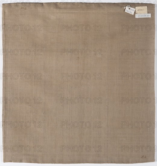 Velum, Velum made of three fragments of white cream satin, embroidered. Below half the height in a medallion is a depiction of Christ at a column Flagellation of Christ iconography, framed by floral sprigs. Background with motifs of floral sprigs of various sizes, including tulips, roses, peonies, chrysanthemums, lilies, lilies of the valley, and sprigs with berries and strawberries. Embellished with gold galloon. Lining made of plain-weave cotton fabric. Flat embroidery with silk yarn in satin, cord, and banner stitches, as well as gold and silver metal thread in a laid stitch. Silk yarn in the following colors: red, cream, yellow, blue, purple, white, and green. 18th century, Poland. Liturgical vestment, fabrics. Height 52 cm, width 49 cm., A square canvas or fabric panel with a plain beige or tan woven surface showing subtle texture and faint variations in tone, with a slightly darker top edge and a few small, darker spots and marks scattered across; the edges show a narrow off-whit...