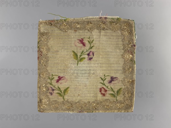 church parament; church paraments; flowers, leaves, plant ornaments; sacred art; churches and chapels furnishings; 2nd half of the 18th century; France; liturgical parament; height 19 cm; width 19 cm, A square piece of fabric with a central panel of light beige or cream-colored woven material showing faint horizontal texture, bordered by an ornate trim with metallic gold threads; within the central area a group of small floral motifs rendered in shades of pink, purple, red, and green with leafy stems; the backing and edges show hints of green and muted red, and the background behind the fabric is a smooth gray.