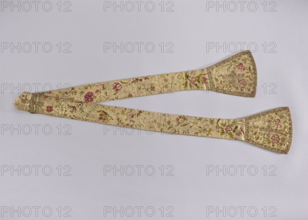 Stole, church paraments; white silk stole embroidered with a pattern of floral sprigs, without a distinct composition; the fabric was probably cut from a larger piece. Equal-armed crosses made of gold lace are sewn into the center of the stole's pallettes and waistband. The edges of the pallettes are trimmed with the same lace. 18th century, Poland; liturgical vestment; length 205 cm, width 18 9 cm., An off-white fabric sash with floral embroidery lies diagonally across a light gray background, forming a gentle V shape; the sash has a pair of wider, trapezoidal end panels edged with decorative trim and the body shows a repeating pattern of embroidered flowers and leaves in pink, red, green, and gold tones against a cream base.