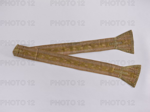 Stole made of silk fabric with olive-colored stripes. Embroidered with a pattern of leaves on the wider stripe, narrower stripes with cherry-colored dot motifs. Pallettes trimmed with braid. Essence-armed crosses sewn from the same braid in the center of the pallettes and the stripe of the stole. Linen lining. 2nd half of the 18th century, Poland. Liturgical vestment; length 180 cm, width 17 cm., A long, narrow decorative textile laid flat in an overlapping arrangement, showing a pair of tapering ends with flared triangular tips and a central section with a repeating leaf-like pattern; the fabric displays colors including gold, olive green, pink, and a muted beige, with metallic trim at the flared ends and subtle woven stripes along the length.