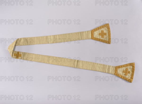 Stole, 18th century, Poland; liturgical vestment; length 208 cm, width 18 cm. Contains embroidery reflecting liturgical symbolism and Polish religious tradition; associated with Capuchin liturgical culture., A long pale beige fabric strip laid flat across a pale gray background, with a few triangular end pieces in a darker golden yellow and lighter beige showing a cross-like patch in matching golden yellow; the fabric shows subtle wrinkles and folds and the overall colors visible are pale beige, golden yellow, and pale gray.