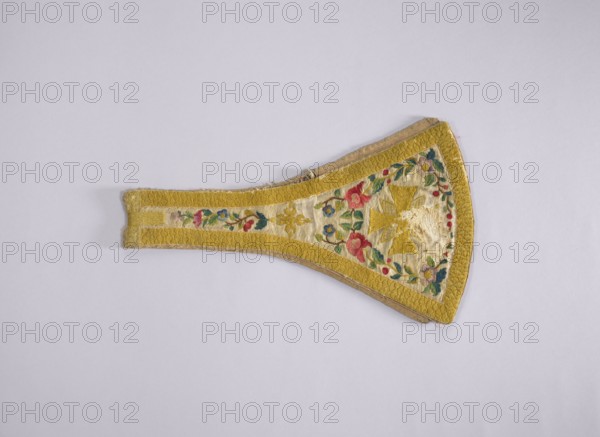 Maniple, 18th century, Poland. Liturgical vestment made of woolen fabric, length 74 cm, width 22 cm. Embroidered along the edges with floral tendrils; equal-armed crosses embroidered at the ends of the paddles in the center. A floral rosette motif embroidered where the paddles merge into the maniple's belt. Around the edges is an embroidered band with a carp scale motif imitating gold braid. Predominant colors: white background with yellow, green, red, and blue ornamentation. Function: church paraments, sacred liturgical vestment., A decorative textile piece shaped like a tapered fan with a wider rounded end, featuring a golden yellow border and central panel on a pale cream background; the central area is embroidered with floral motifs in red, pink, blue, green, and purple, along with gold-colored geometric elements, and the narrower end shows a continuation of the floral embroidery and yellow border.