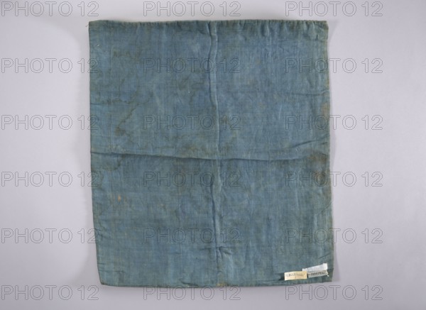 Velum; creator, church paraments; revindication provenance; flowers, leaves, plant ornaments; sacred art; churches and chapels furnishings; 18th century; France; liturgical parament; height 47 cm; width 54 cm, A rectangular piece of fabric laid flat on a lighter background, showing visible creases and fold lines; the fabric is primarily a muted blue with areas of darker and lighter blue and some subtle greenish-blue tones, along with small brownish discolorations and faint worn spots; the edges are slightly uneven and there is a small folded corner at the bottom, with a few tiny irregular marks and variations in texture across the surface.