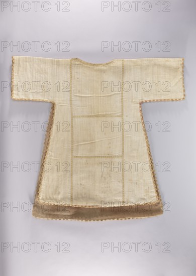 Dalmatic, dalmatic, flowers, leaves, liturgical vestments, plant ornaments, church paraments, sacred art, churches and chapels furnishings, 2nd half of the 18th century, liturgical vestments, height 120 cm, width 85 cm, height 110 cm, width 79 cm, A flatlaid garment with a T-shaped silhouette made of a pale beige fabric with faint vertical ribbing, featuring wide straight sleeves and a rounded neckline, trimmed along the edges with a scalloped border in muted gold and a few touches of pink; the lower hem has a wider band of light brown velvet, and the fabric shows subtle creases and slightly darker spots in places against a soft light gray background.