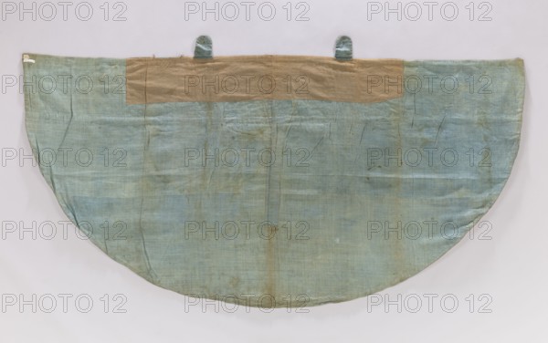 Church cope of silver brocade with Chinese motifs. Pretext sewn from two Polish fabrics: cream satin with a floral pattern and sky-blue satin with blue stripes, trimmed with galloon. Hood trimmed with fringe; silver buckle with a carp-scale motif. Skirt of silk lampas, woven with a blue silk weft and embellished with metal thread and silk yarn; background satin warp shows liseré decoration forming the overlay. Motifs symmetrically composed of large fanciful vases with Chinese figures topped by Chinese-style buildings forming a chalice; between these are birds and elements of Chinese architecture in a chinoiserie style. Metal brocade thread on a loosely braided, crimped white silk core; broidering threads: braided metal thread and orange, blue, white, yellow silk yarn. Measurements: height 51 × width approx. 77 cm report; skirt fabric/vestment length 128 × width 254 cm entry. France, early 18th century silk fabric for the skirt; overall 18th century liturgical vestment., A large semicir...