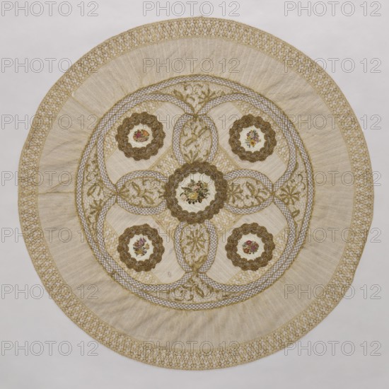 Doily, doilies, decorative fabric, lace, embroidery. Round doily sewn from two pieces of machine lace, bobbin lace, and fabric with colorful petit point embroidery. Five medallions are arranged in the central circle, each surrounded by bobbin lace, with four oval lace medallions with floral branches between the medallions. Mid-19th century, Europe. Fabric, lace; diameter 115 cm., A circular textile with a central round medallion and a symmetrical arrangement of smaller round motifs, all set within concentric ornamental bands; the piece features intricate lacework and embroidered floral designs, with scalloped floral frames around the round motifs, interlaced ribbon-like patterns connecting them, and leaf-and-vine motifs filling oval spaces; the colors visible are cream, beige, gold, brown, green, pink, and red; the outermost edge shows a decorative woven border, followed by a wide pleated or gathered band, then a fine netted area leading into the central embellished section.