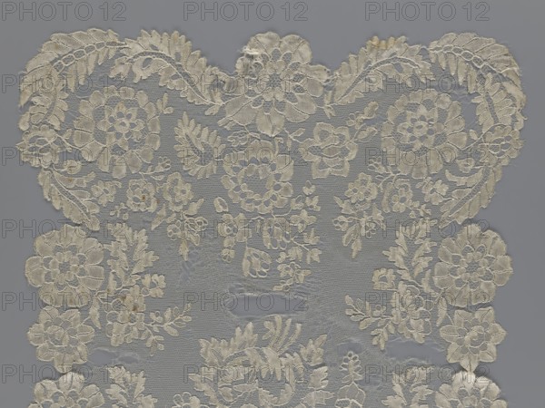 Shawl, shawl, clothing accessory, women's clothing, fashion, lace with serrated edges, pattern of twigs with two flowers in the bends and curling flower twigs in the central area, 19th century, Europe; length 48 cm, width 260 cm., The image shows a piece of lace fabric with a floral and leafy pattern in off-white and cream tones set against a muted gray background; the lace has a delicate openwork net structure with embroidered flowers, petals, and fern-like leaves arranged symmetrically across the surface, and there are a few areas where the threads appear slightly frayed or uneven.