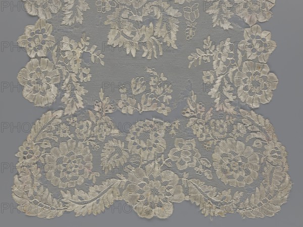 Shawl, shawl, clothing accessory, women's clothing, fashion, lace, serrated edges, in the bends twigs with two flowers, in the middle part curling flower twigs, 19th century, Europe, lace, length 48 cm, width 260 cm, The image shows a piece of delicate lace with an intricate floral pattern laid over a flat background. The lace features a variety of flower and leaf shapes connected by fine net-like threads, with scalloped edges and several clusters of petals and foliage. Visible colors include off-white and cream tones in the lace and a solid gray background.