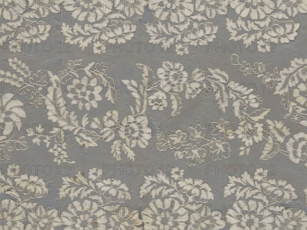 Shawl, shawls, clothing accessories, women's clothing, fashion, lace, serrated edges, in their bends twigs with two flowers, in the middle part curling flower twigs, 19th century, Europe, length 48 cm, width 260 cm, A patterned textile with an overall gray background featuring a repeating floral lace design in off-white and cream tones; the lace motifs include several clusters and wreath-like arrangements of stylized flowers, leaves, and vines with delicate openwork and scalloped edges, and there are subtle variations in the off-white areas where some parts appear slightly aged with faint tan or beige discoloration.