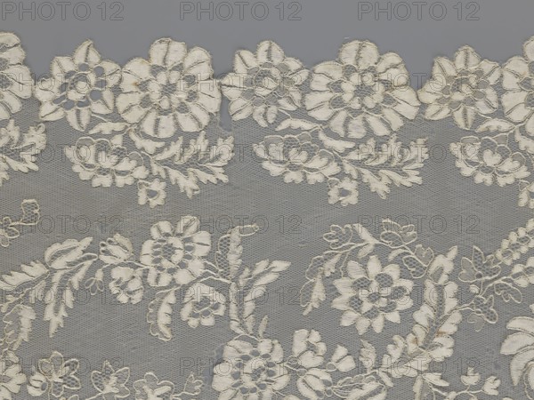 Shawl, shawl, clothing accessory, women's clothing, fashion, lace, serrated edges; design: in the serrated bends twigs with two flowers and in the middle section curling flower twigs. 19th century, Europe. Lace shawl; length 48 cm, width 260 cm., A patterned textile showing a lace-like floral design in off-white set against a grey background, featuring a group of large stylized flowers with layered petals and smaller floral clusters connected by leafy vines and tendrils, with areas of open netting between the motifs and visible stitched edges and threads.