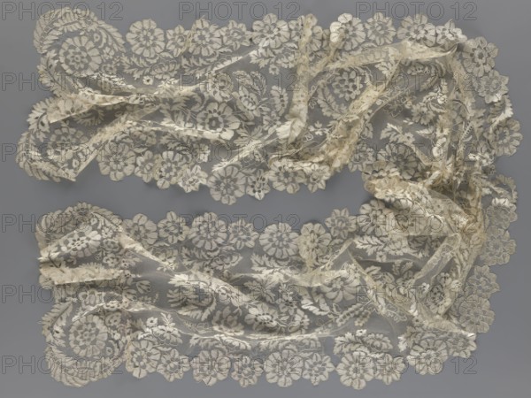 Shawl, shawl, clothing accessory, women's clothing, fashion, lace with serrated edges; design includes twigs with two flowers in the bends and curling flower twigs in the middle part. 19th century, Europe. Length 48 cm, width 260 cm., A delicate piece of lace fabric arranged in two loose horizontal bands against a flat background, showing an ornate floral pattern with scalloped edges; the lace displays a mix of creamy off-white and beige tones with translucent areas where the netting shows through, and subtle shadowing that gives the fabric a slightly wrinkled, layered appearance.