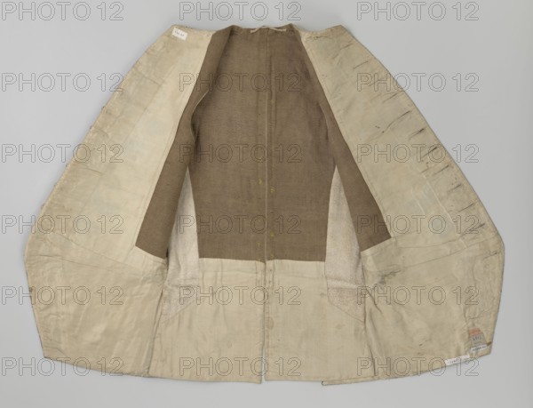 Vest, Repossession provenance. Floral and plant ornaments; patterned brocaded silk fabric, predominant colors silver, plum, green, and raspberry. Front of brocaded silk; motifs arranged around the edges. Fastened with 12 buttons embroidered with gold threads. No collar. Side flaps with flapped pockets; three buttons under the flaps as for the closure. Back: bottom and sides of fabric as on the front, but cut-out pieces are plain without brocade. Cream silk lining. 1740–1760, England fabric possibly from Silesia. Garment; length 74 cm., An open garment laid flat showing its interior with a central brown fabric panel and inner sleeves of the same brown, surrounded by an off-white or beige lining that extends to the edges; the lining shows visible seams, stitching, and some darker smudges and worn areas, and there are a few small patches where the lining texture differs slightly in tone, with the overall palette consisting of brown, off-white, beige, and subtle hints of gray.