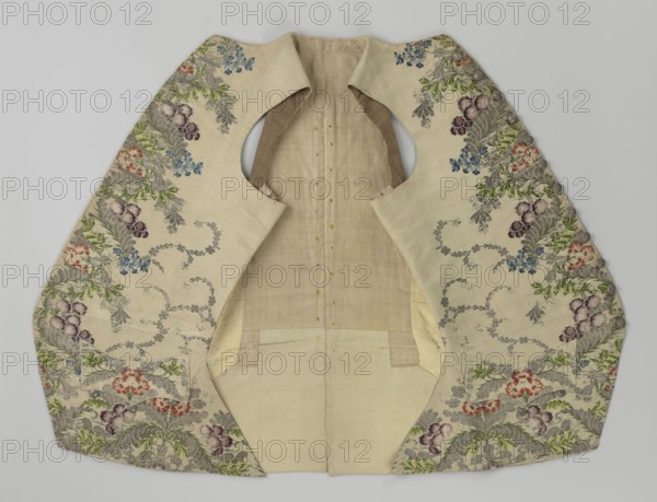 Vest, Repossession provenance. Floral and plant ornaments; patterned brocaded silk fabric, predominant colors: silver, plum, green, and raspberry. Front: motifs arranged around the edges; fastened with 12 buttons embroidered with gold threads; no collar; side flaps with flapped pockets, three buttons under the flaps for closure. Back: bottom and sides of fabric as on the front, but cut-out pieces are plain without brocade. Cream silk lining. Dated 1740–1760. Origin: England fabric possibly, Silesia. Garment; length 74 cm., A garment laid flat showing the interior and decorative outer panels, primarily cream and beige, with a few areas of light brown lining; the outer panels feature an embroidered floral pattern with green leaves, blue flowers, purple flowers, and red or coral flowers, along with grayish fern-like motifs; the embroidery appears along the edges and around the arm openings, forming flowing curved shapes; the central interior section is plain beige with a few small buttonh...