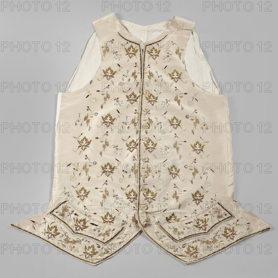 Vest, 2nd half of the 18th century, Poland. Garment, length 74 cm. Fastened to the neck with 9 covered and embroidered buttons. Side flaps with pockets underneath. Laced canvas back. Floral and geometric ornaments., A sleeveless garment laid flat on a neutral gray background, made of a pale cream fabric with a slightly shiny finish and a lighter cream inner lining visible at the arm openings; the front panels feature a repeated floral embroidery pattern in shades of olive green, muted gold, soft brown, and pale beige with small accents of darker brown and subtle touches of light green, and a vertical trim runs down the center front; the hem has two pointed flaps with additional embroidered floral motifs and decorative borders in the same color palette, and the garment shows stitched seams and a small standing collar in the same pale cream tone.