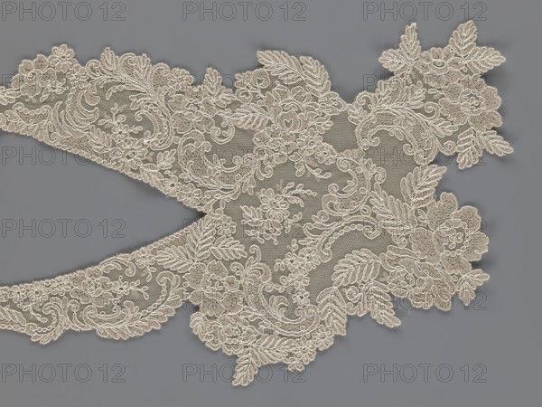 Collar, origin unknown, floral ornaments, clothing accessory for women's fashion, embroidery. Connected at the bottom by a wide, irregular inset. 2nd half of the 19th century, Europe. Width 19 cm, length 50 cm., A piece of ornate lace with floral and leaf motifs arranged in a curved, scalloped shape, shown against a solid background; the lace is a light beige or cream color with intricate raised embroidery and delicate netting, featuring swirling vine-like patterns, clusters of flowers, and leafy fronds, and the background is a smooth medium gray.