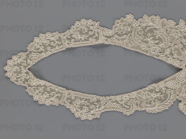 Collar, creator unknown, origin unknown, floral ornaments; clothing accessory for women's fashion; embroidery; connected at the bottom by a wide, irregular inset; 2nd half of the 19th century, Europe; width 19 cm, length 50 cm., A decorative scalloped lace trim in an off-white or cream color arranged in an elongated oval shape against a flat medium gray background, showing intricate floral and scrolling motifs worked on a fine net ground with raised embroidered outlines, small layered flowers, leaf shapes, and curving paisley-like elements, the lace edge alternating between rounded scallops and pointed floral projections, with delicate open mesh areas contrasting the denser embroidered sections.