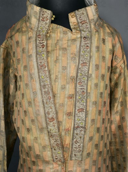 Zupan from the uniform of the Order of St. Stanislaus. Zupan made of pink and crimson Grodno fabric with stripes and a small floral pattern. Fitted at the top, slightly flared at the bottom. Fastened at the front to the neck with haberdashery buttons. High, stand-up collar, adjustable at the back with a buttoned flap. Long, set-in sleeves with turn-up cuffs fastened with hooks. Around the fastener, on the sleeve seams and cuffs, gold-leaf galloon with floral sprigs and baskets. Back of crimson satin, cut with a central column of fabric like a kontusz, widened from the waist on the sides by semi-flared pleats, adjustable at the top with ribbons. Back and lining of white silk satin. Hand-sewn. Zupana fabric: crimson silk grosgrain brocaded with braided gold thread and silk wefts; gold stripes on a crimson background and miniature sprigs of stylized flowers. Grodno, 1780s. Gold galloon with a fine floral pattern. Materials/measurements: fabric sample 5 x 4.5 cm, fabric length 55.5 cm, fab...