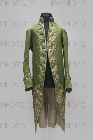 Habit à la française, repossession provenance; floral and plant motifs; fashion, men's clothing; embroidery; 18th century clothing. Habit of green silk embroidered with motifs of small bouquets of flowers. Fitted at the top, widened at the back from the waist down with two slit pleats. Fastens at the front with hooks and eyes. Semicircularly cut lapels overlap at breast level and are cut off at the bottom. High, standing collar. Long sleeves set in at elbow height, cut in an arc, finished with wide, slightly protruding cuffs. Side pockets at hip level covered with trapezoidal flaps. Back cut with a center seam; slits at hip level. Center back flaps meet without a pleat. Embroidery runs in a wide band around the edges, cuffs, pockets, collar, and back pleats. Decorative buttons sewn in threes on the cuffs, under the pocket flaps, two at the top of the back pleats, and in the pressed pleats. 1770s, Silesia place of origin; France place of creation. Garment; length 112 cm., A long, green ...