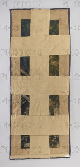 Fragment of verdure tapestry, flowers, leaves, floral ornaments, trees, birds, landscapes, interior furnishings, weaving; densely growing tree branches occupy the entire surface; at the bottom, tall plants with broad, heart-shaped leaves; a crested bird a hoopoe is visible in the dense foliage; no border. Colors: navy blue, blue, green, and beige. 17th–18th century, Flanders. Fabric. Height 336 cm, width 136 cm., A rectangular textile with a narrow dark gray border surrounds a patchwork of beige panels arranged in horizontal bands, with several vertical dark green panels featuring floral or leafy patterns partially visible between the beige pieces; the beige fabric has a slightly wrinkled texture and variations in shade, and the dark green patterned sections show muted blues, greens, and touches of golden tones; the overall background behind the textile is a light neutral color.