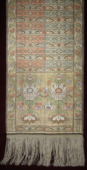 Kontusz belt, Franciszek Maslowski's Studio Kraków; belt manufacturer; 1781-1806. Polish kontusz belt, solid four-sided belt, plant ornament, flowers and flower bushes; national costume accessory. Ornament: Heads — two bouquets of fanciful flowers growing from a bunch of leaves and flowers. Centre — alternating transverse shelves with rosette and floral tendril motifs. Edges — vertical and horizontal with floral tendril motifs; horizontal ones match the shelves. Borders — serrated edges and a ladder pattern. Colors: Right — background of heads, borders and shelves with the twig in gold; ornament in silver, pink, blue, white, green and ochre; shelves with rosettes have half pink, half green-blue backgrounds, ornament in gold, brown and half green-blue/half pink. Left — background of heads, borders and shelves with the twig in brown; ornament in gold and same colors as right; rosette shelves have gold background, ornament half cream, half blue. A gold fringe is sewn on. Weave density app...