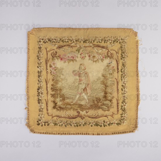 Tapestry hangings, provenance; flowers, floral ornaments; tapestries, interior furnishings, decorative fabrics, weaving; garlands, ribbons, furniture upholstery. Seat with a depiction of a dog sitting on grass, stage surrounded by a floral and acanthus border. Predominant colors: beige background, green, pink, and brown. Backrest with a depiction of a boy in a theatrical costume against a garden background. Stage framed by a floral and acanthus border in the same tone as the seat. Armrests with a depiction of a garland woven from blooming jasmines. 18th century, France; fabrics; height 73.5 cm, width 78.5 cm., A square woven textile with a faded golden yellow border and a central panel showing a pastoral scene; the border features a decorative floral garland in shades of green, brown, pale pink, and cream, with darker brown scrollwork accents at the inner edge. The central panel has a muted beige background and depicts a figure wearing garments in soft pink, cream, and pale green stand...