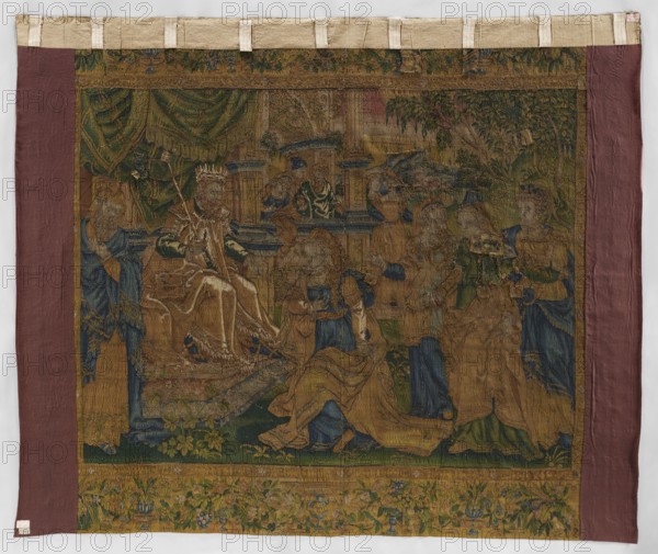 Figural tapestry, tapestries, weaving, interior furnishings, decorative fabrics, interior decorations, biblical scenes, verdigris, tapestries. On the right, the king wearing a crown and a scepter sits on a throne under a canopy, next to courtiers. A young woman kneels before the king, and behind her are three ladies-in-waiting. In the background, in the center, in terraced buildings, other courtiers. In the distance, a landscape. Surrounded by a border with floral and leaf motifs; in the corners, under canopies, female figures. Colors: green, sand, blue, yellow, and ochre. Late 16th century, Flanders. Fabrics; height 296 cm, width 355 cm., A worn woven tapestry mounted on a rectangular backing featuring a central scene with a seated crowned figure wearing a robe and holding a scepter, surrounded by several standing and kneeling figures in long garments. The scene includes architectural elements like columns and draped curtains, foliage and trees at the top and sides, and a decorative f...