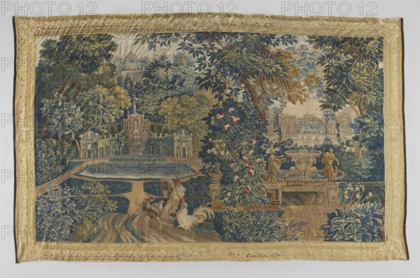 Tapestry — verdure. In the foreground, two fighting roosters. On the right, a fountain in the form of a round bowl supported by dolphins and surrounded by two statues. On the left, a water pool surrounded by arcaded niches with statues, and on its axis, a water cascade. In the background, on the right and left, palace buildings. Around, trees and flowers. Border with rosette and rhombus motifs. Flowers, floral ornaments, birds, garden scenes, decorative fabrics, animalistic and landscape scenes, garden and park sculptures and architecture. Colors: green, blue, ochre, gold, red and sand beige. 18th century, Flanders. Fabric. Height 290 cm, width 465 cm.,  noted., A large woven textile with a wide golden border surrounds a detailed garden scene dominated by shades of green, blue, gold, and tan. The central area shows a formal water feature with a rectangular reflecting pool in blue, stepped terraces, sculpted stonework, and a fountain. Lush trees and dense foliage in various greens and b...