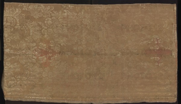 Fabric fragment, fragments of silk fabrics, patterned pseudo-damask with floral and plant patterns and stripes, fabrics with preserved selvedge, preserved ply width and preserved repeat. Fragment sewn from two salmon-white damask-type fabrics prominent stripes, differing slightly in pattern and ply width. 1. Damask effect achieved by different colors of warps and wefts. Pattern in mirror symmetry. Tiny blossoms spill out from large blooming peony-type flowers. White taffeta background, salmon pattern — gros de Tours. Repeat: height 29 x width 49.5 cm; edge width 0.5 cm. 2. Damask effect achieved by different colors of warps and wefts. Pattern in mirror symmetry. Large fruit and blooming flowers, lace motifs resembling combs of French needlepoint lace. White taffeta background, salmon pattern — gros de Tours. Repeat: height 38.5 x width 50.5 cm; edge width 0.4 cm. Date: 1735–1745. Place of origin: France. Overall dimensions: height 98 cm, width 97 cm., A rectangular piece of fabric with...