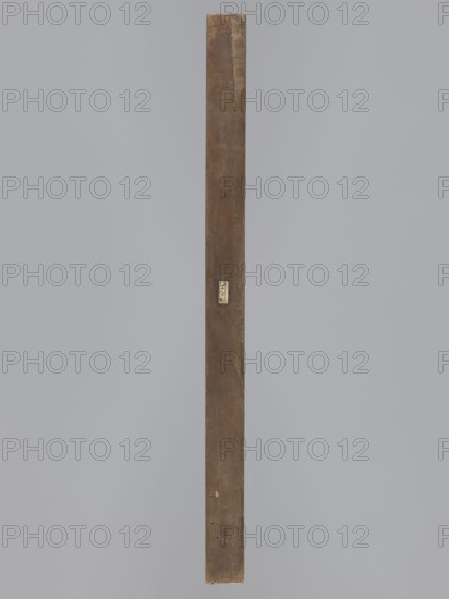 Double-sided gingerbread mould. Side A: image of a bachelor; Side B: baby in swaddling clothes., woodcarver or gingerbread maker. Double-sided, rectangular mould. One side: man in a long wig and tricorn hat, dressed in costume probably dating from the turn of the 17th and 18th centuries—justaucorps with decorative cuffs, culottes and stockings, and high-heeled shoes; at his feet floral and geometric decorative motifs and the date 1827. Other side: baby in swaddling clothes richly decorated with geometric and plant ornament. Inscription on the edge: FW FIEBIGER. a. BAUTZEN. 17 signature of the manufacturer and beginning of the date. Silesia Prussia; 1742–1918 folk motifs; gingerbread mould; decorative art; folk customs; historical costumes; plant ornaments; floral decorations; male figures. Date: 1827. Place: Bautzen. Form. Dimensions: height 64 cm, width 22.5 cm, depth 4.3 cm., A long vertical wooden plank with a weathered brown surface stands against a smooth gray background; the plan...