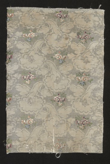 Fabric fragment, fragments of silk patterned fabric with floral patterns. Fragment of silver-and-white fabric with miniature flower bouquets. Report: length 21.5 cm; overall height 37.5 cm, width 24 cm. 2nd half of the 18th century, France., A rectangular piece of fabric with a pale beige and light gray background featuring a repeating cloudlike pattern and scattered small floral bouquets; the flowers show shades of pink, red, blue, and white with green leaves, and there are subtle metallic-silver threads woven throughout; the fabric edges are slightly frayed and the piece rests on a dark black background.