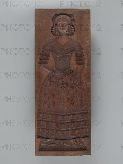 Double-sided gingerbread mould. Side A: figure of a lady; Side B: figure of a bachelor., woodcarver or gingerbread maker. Rectangular form, 19th century dated 1842. Height 84.5 cm, width 32 cm, depth 4 cm. Silesia Province of Silesia, 1742–1918. Materials/subject: gingerbread mould; gingerbread; decorative art; folk motifs; historical costumes; floral ornaments; female figures in rich dresses; male figures; youthful figures. Description: On one side a male figure in a high hat with a cane, wearing an outfit from the first half of the 19th century—frock coat, coat and checked trousers—with a dog at his feet standing on its hind legs. The other side shows a female figure wearing a decorative bonnet and a long patterned dress decorated with numerous ruffles and ribbons, holding a fan and a handbag in her right hand and a bunch of feathers, in her left. Under the legs of both figures is plant decoration. On the edge are carved decorative letters: ACL a. P, initials of the woodcarver or gin...